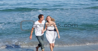 Happy lovers having fun at the seaside