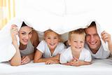 Smiling family lying together on bed