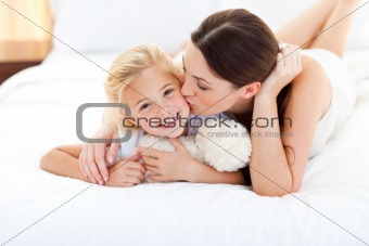 Attractive mother kissing her little girl 