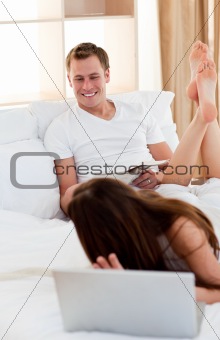 Affectionate lovers talking lying on bed