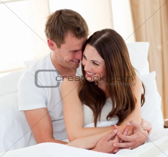 Romantic lovers embracing lying in bed