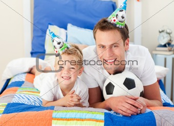Happy child and his father playing with a soccer ball