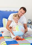 Father and son looking at a terrestrial globe