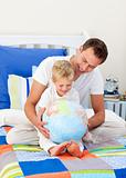 Enthusiastic father and his son looking at a terrestrial globe