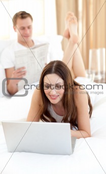 Brunette woman with her husband working at a laptop
