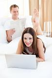 Attractive woman with her husband working at a laptop