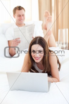 Attractive woman with her husband working at a laptop
