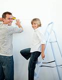 Smiling father and his son decorating a room 