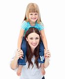 Attractive brunette mother giving her daughter piggyback ride