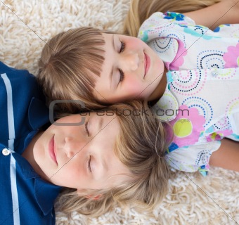 Cute siblings lying on the floor with heads together