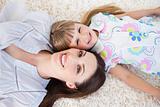 Smiling mother and her daughter lying on the floor