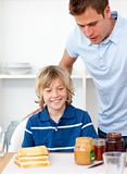 Blond little boy and his father preparing breakfast 