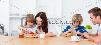 Happy family eating breakfast in the kitchen