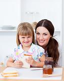 Cute little girl and her mother eating slices of bread
