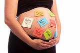 Pregnant Caucasian woman with sticky notes on belly