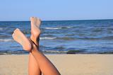 lovely legs on the beach on blue sky