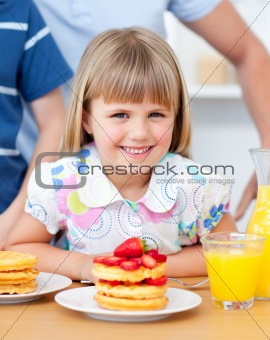 Portrait of a cute little girl having breakfast in the kitchen