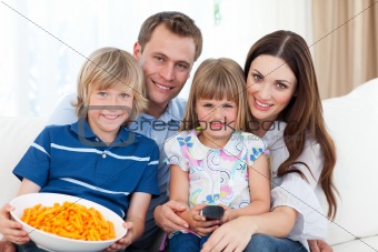 family watching television and eating popcorn at home