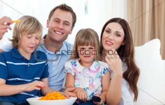 Happy family eating crisps 