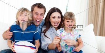 Smiling Young family watching TV on the sofa