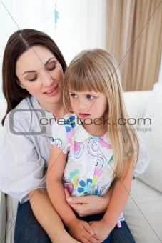 Cute blond girl sitting on her mother's lap