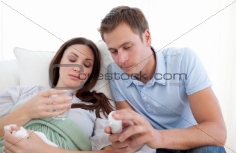 Young man looking after his wife with the flu 