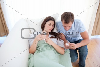 Man giving pills to his sick wife 