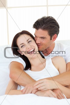 Intimate couple hugging lying in the bed