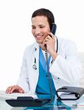 Young male doctor on phone working at a computer