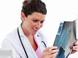 Smiling female doctor looking at X-ray in his office