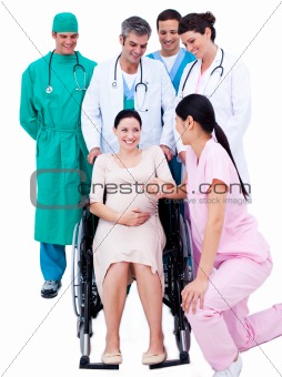 Medical team standing around a pregnant woman 