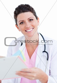 Brunette doctor reading paper and holding a stethoscope
