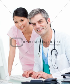 Confident doctors working at a computer
