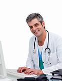 Mature male doctor working at a computer