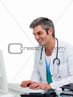 Smiling male doctor working at a computer