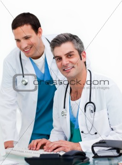 Two concentrated male doctors working at a computer