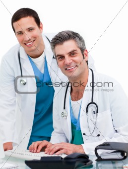 Two handsome male doctors working at a computer