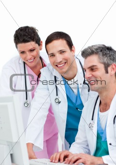 Smiling medical team working at a computer