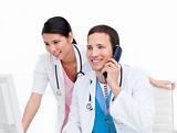 Two happy doctors talking on phone