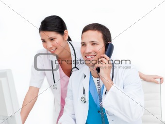 Two happy doctors talking on phone