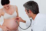 Brunette pregnant woman examined by her gynecologist