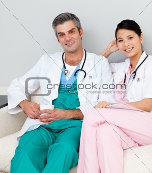 Smiling doctors relaxing and drinking coffee