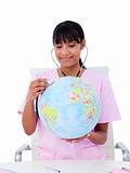 Portrait of a female doctor examining a terrestrial globe