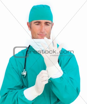 Pensive doctor looking at his surgical gloves