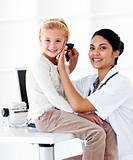 Smiling female doctor checking her patient's ears 