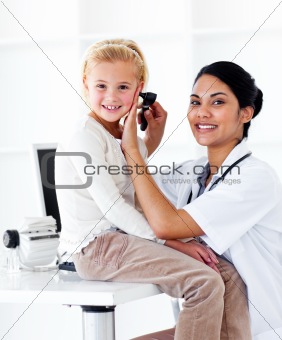 Smiling female doctor checking her patient's ears 