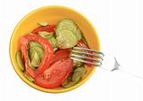 Salad from fresh cucumbers and tomatoes on a yellow plate