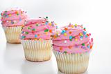 shot of Three cupcakes with sprinkles in a line
