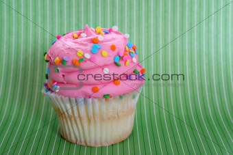 shot of a gourmet cupcake on green background