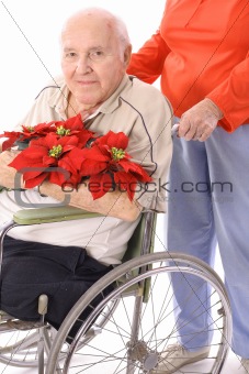 shot of a wife pushing handicap man in wheelchair with flowers
